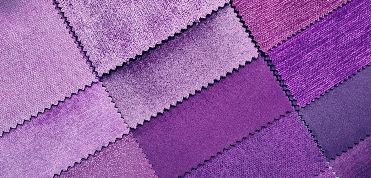 Swatches of different shades of purple fabric arranged on a table