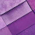 Swatches of different shades of purple fabric arranged on a table