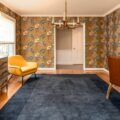 How to make a space truly yours without buying new furniture: vibrant room with yellow armchairs, floral wallpaper, and modern rental pieces from CORT.