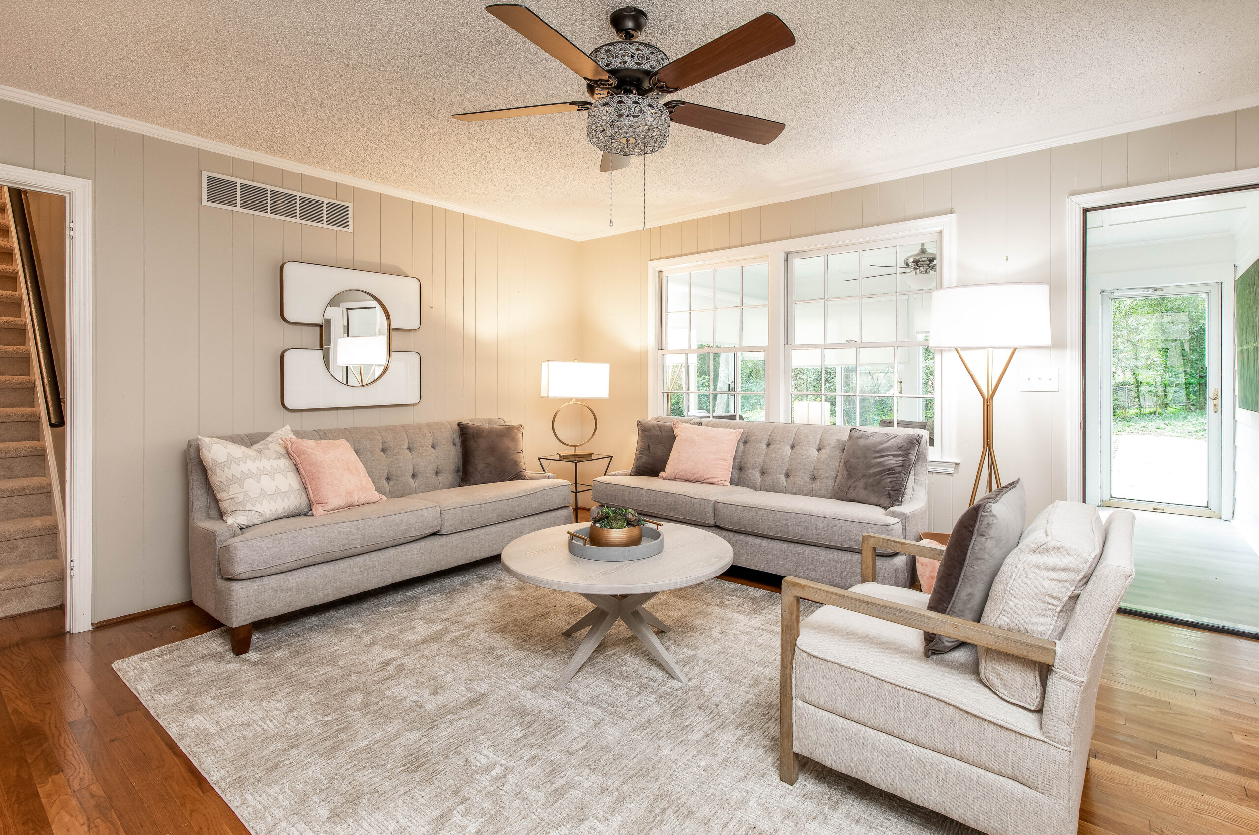 Warm-toned living room with gray sofas, natural light, and soft lighting in a rental home