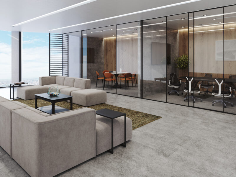 Office lounge with modular seating and glass-walled meeting rooms, illustrating a Furniture-as-a-Service layout designed for adaptability and team mobility.
