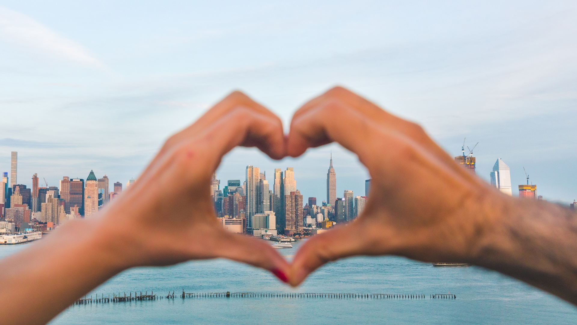 Hands making heart in front of NYC while preparing for an internship in NYC.