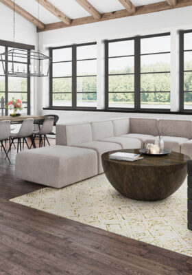 Stylish open-concept living and dining area with modern furniture rental from CORT, featuring the Marin sectional, black arm chair, lark cocktail table, and additional wooden accents